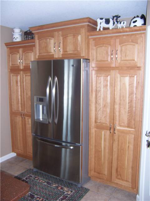 Cherry pantry cabinets with natural finish - Raised panel doors - Standard overlay style